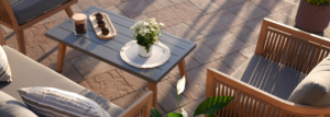 Nahaufnahme, Holzsofa und Tisch aus Metall und Holz im Garten und auf den Gartenziegeln.