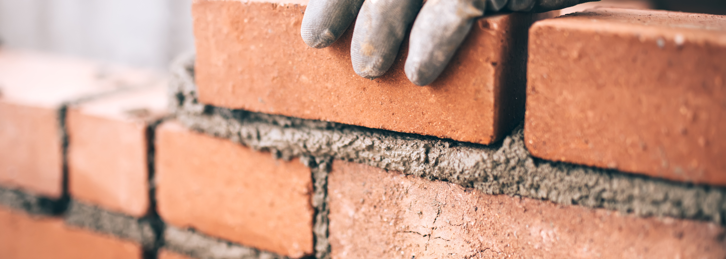 Handschuh auf Ziegelstein. Ziegelsteine mit Zement. Mauer.